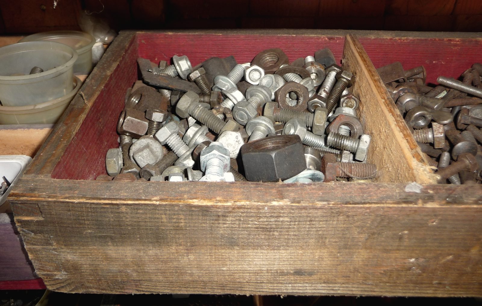 A wooden tray of hex bolts and nuts