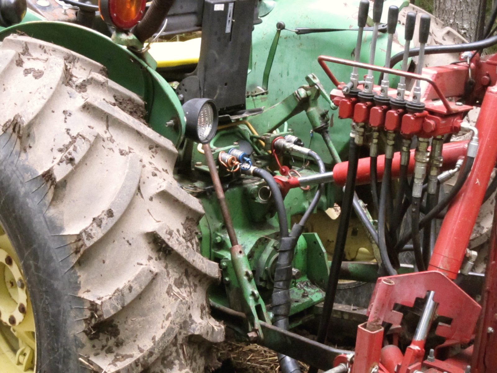 Hydraulic hoses and control valves on a farm tractor with a post driver